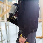 Using portable cordless nail gun on woodworking jobsite.